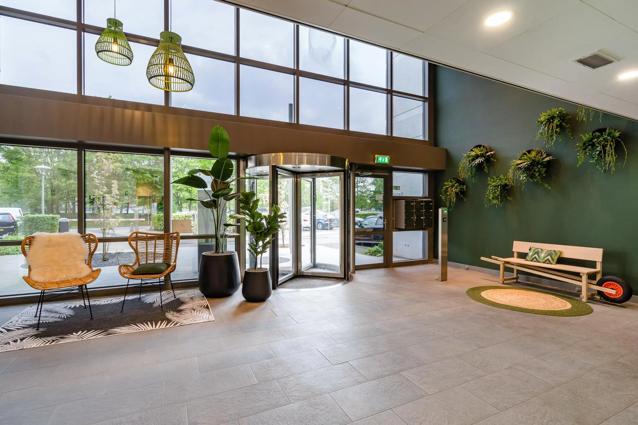 Moderne en sfeervolle entreehal aan de Baarnsche Dijk met zitgedeelte, grote planten en groene accenten.